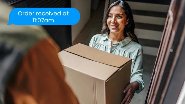Photo of a smiling customer receiving a package from a driver